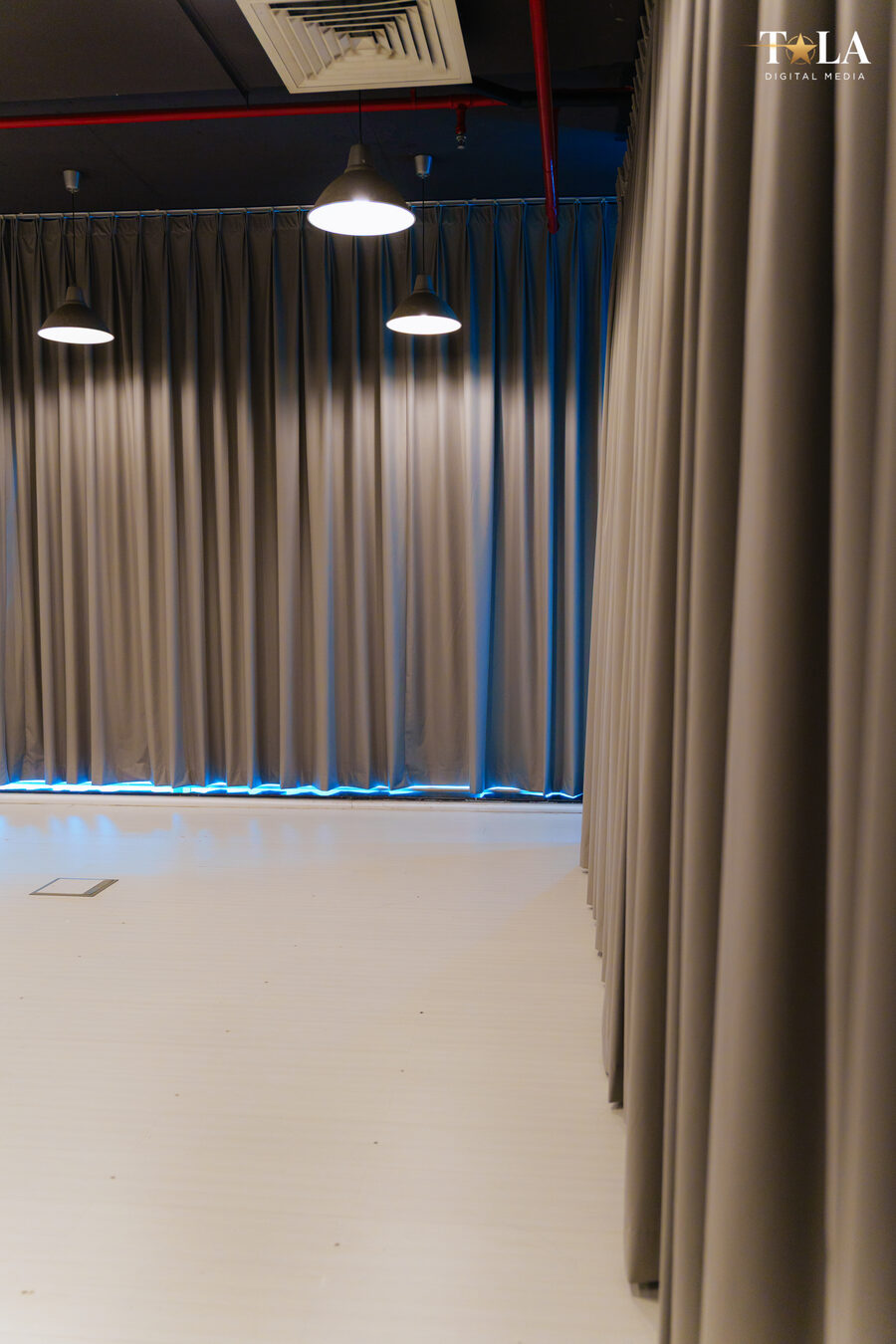Studio backdrop wall detail with pendant lighting and blue ambient accent lighting